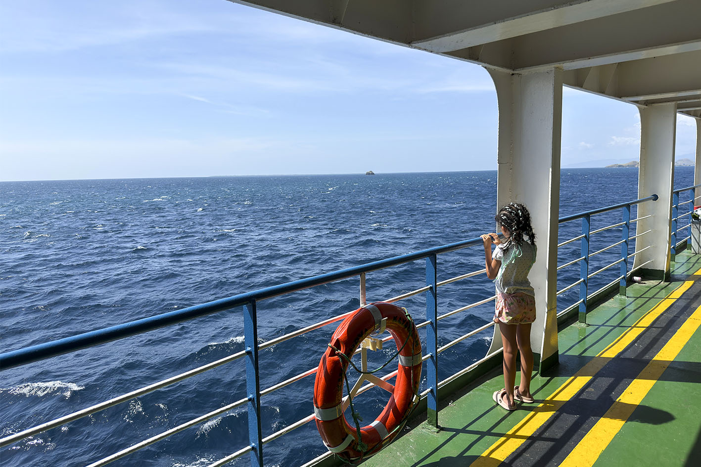 Come arrivare a Sumbawa Ovest. Una bambina aggrappata alla ringhiera del traghetto.