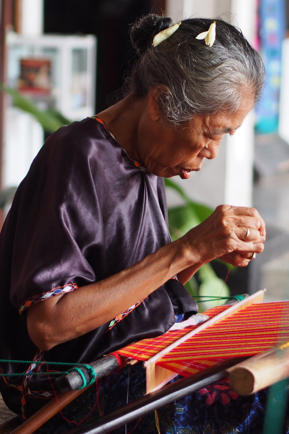 Lombok vedere e fare. Una donna anziana tesse un songket.